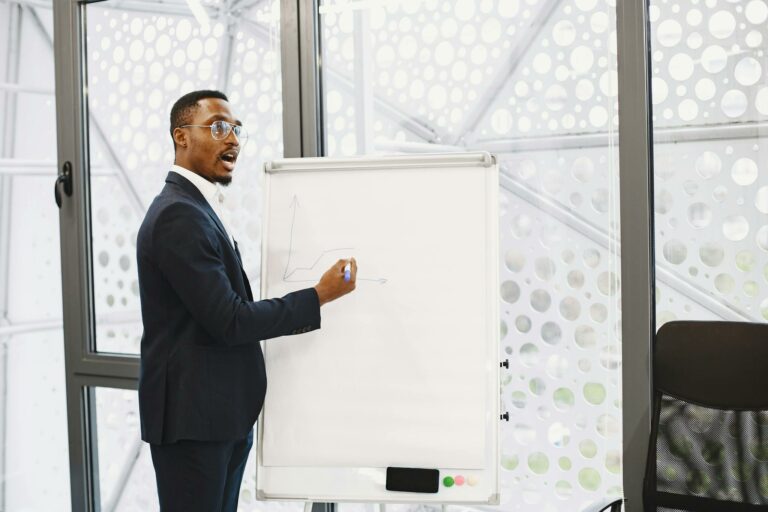 Businessman presenting on a flip chart in a contemporary office setting.